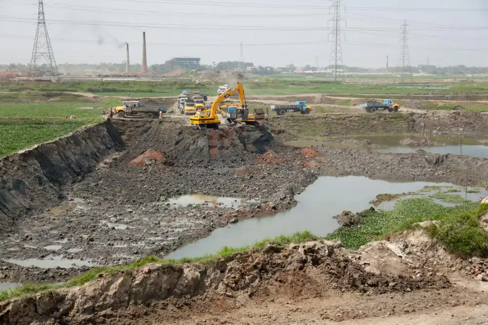 Heavy machinery constructing fish pond dikes